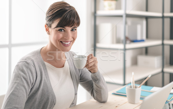 Kávészünet iroda vonzó nő dolgozik irodai asztal laptopot használ Stock fotó © stokkete