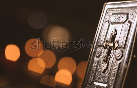 Precious old Bible and lit candles in the Church Stock photo © stokkete