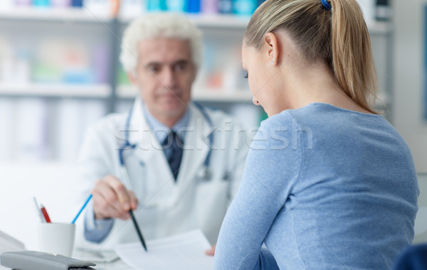 Doctor showing medical records to the patient Stock photo © stokkete