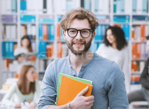 Hipszter egyetemi hallgató tart jegyzetfüzetek mosolyog diákok Stock fotó © stokkete