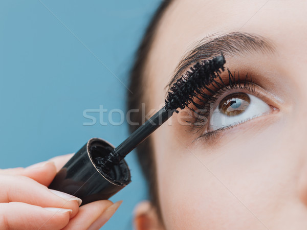 Woman applying mascara on her lashes Stock photo © stokkete