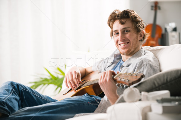 Fiatal gitáros otthon fiatalember játszik gitár Stock fotó © stokkete