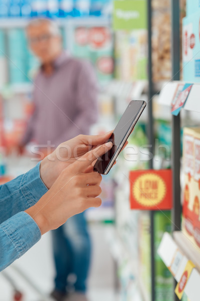 Woman shopping and using her phone Stock photo © stokkete