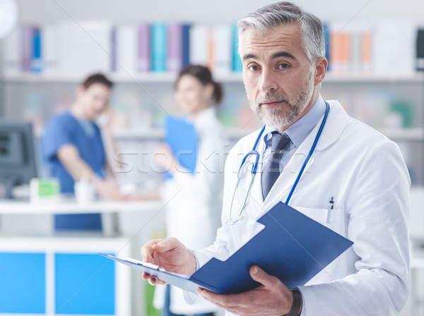 Confident doctor checking medical records Stock photo © stokkete