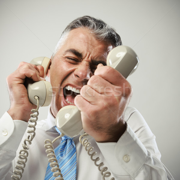 Businessman yelling into phone Stock photo © stokkete