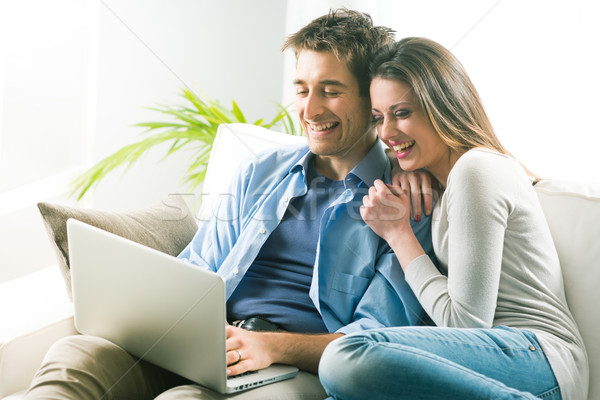 Couple relaxing on sofa with laptop Stock photo © stokkete