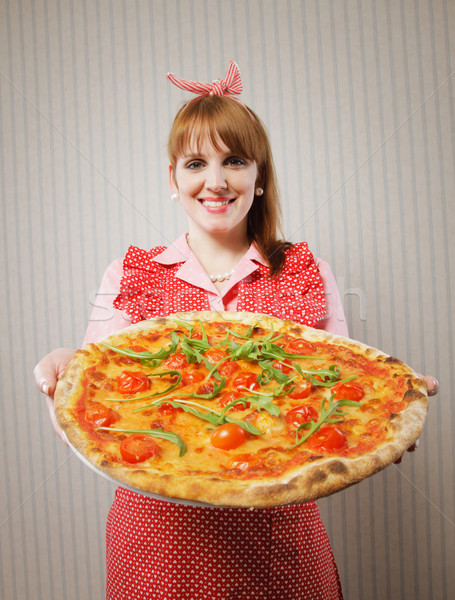 Retro Housewife holding a vegetarian pizza Stock photo © stokkete