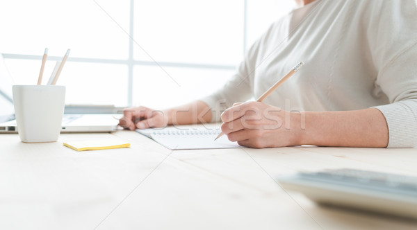 Fiatal designer jegyzettömb fiatal nő ül asztal Stock fotó © stokkete