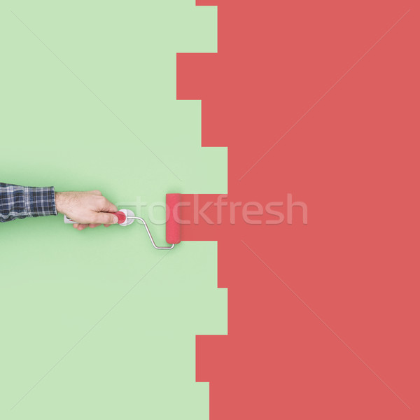 Stock photo: Decorator painting a wall with a paint roller