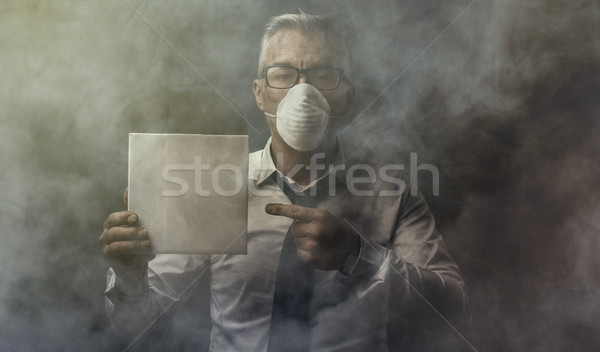 Businessman holding a sign and air pollution Stock photo © stokkete
