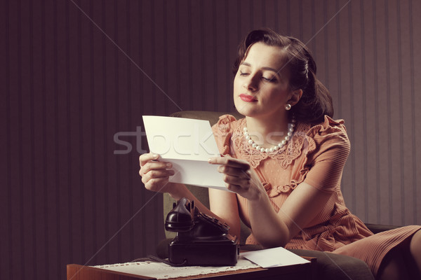 Hírek fiatal nő olvas levél ül fotel Stock fotó © stokkete