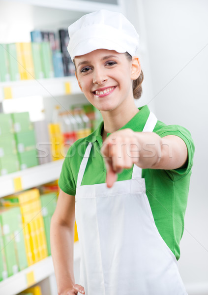 Sales clerk smiling and pointing at camera Stock photo © stokkete