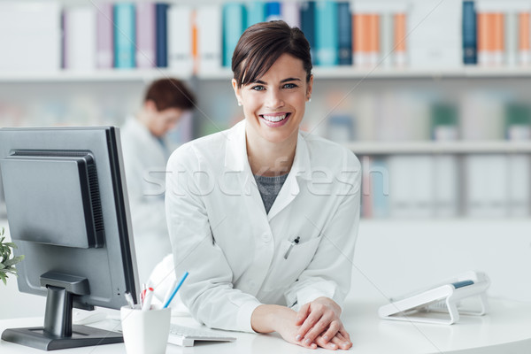 Lächelnd Arzt Klinik weiblichen besetzt Schreibtisch Stock foto © stokkete