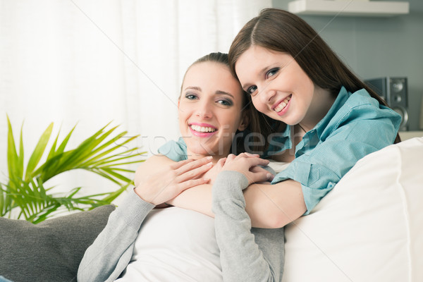 Girlfriends hugging on sofa Stock photo © stokkete