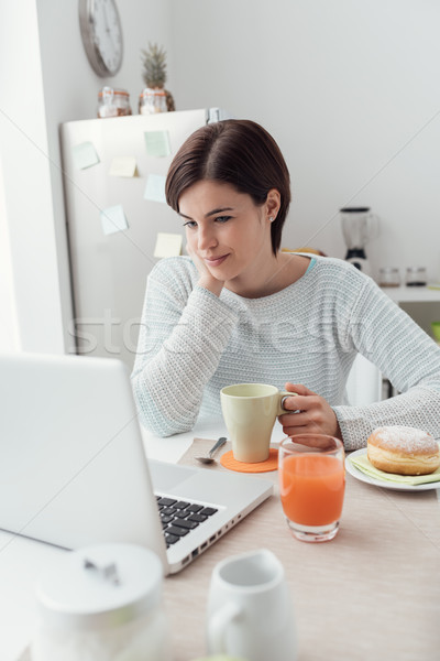 Woman connecting in the kitchen Stock photo © stokkete
