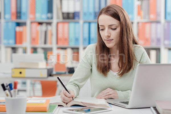 Egyetemi hallgató olvas tankönyv fiatal női ül Stock fotó © stokkete