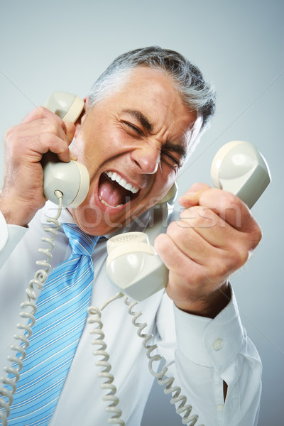 Businessman yelling into phone Stock photo © stokkete