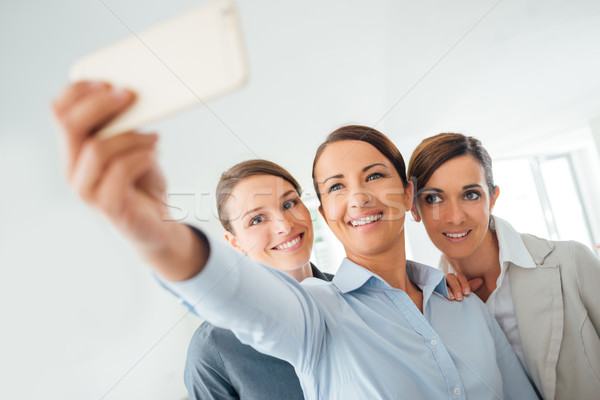 Smiling business women team taking a selfie Stock photo © stokkete