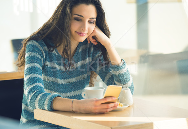 Confident young woman at the cafe using a smartphone Stock photo © stokkete