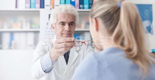 Ophthalmologist giving glasses to the patient Stock photo © stokkete