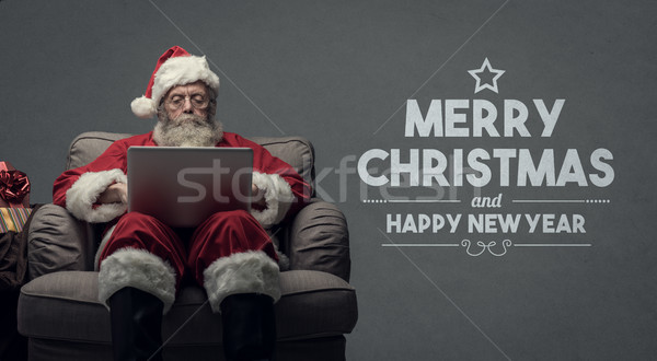 Santa Claus connecting with a laptop Stock photo © stokkete