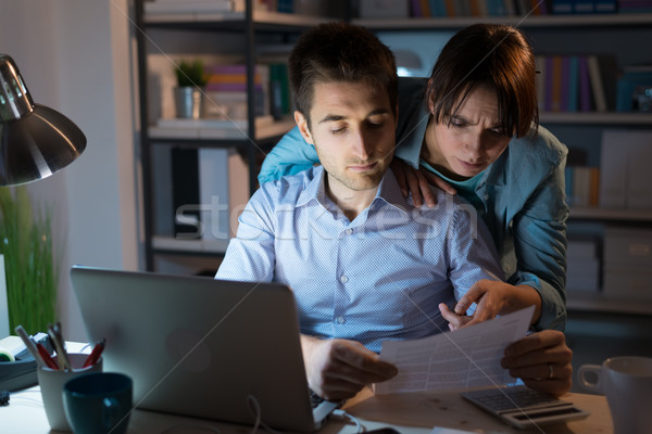 Stock photo: Young couple checking bills at night