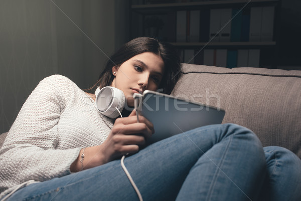 Girl relaxing and using a tablet Stock photo © stokkete