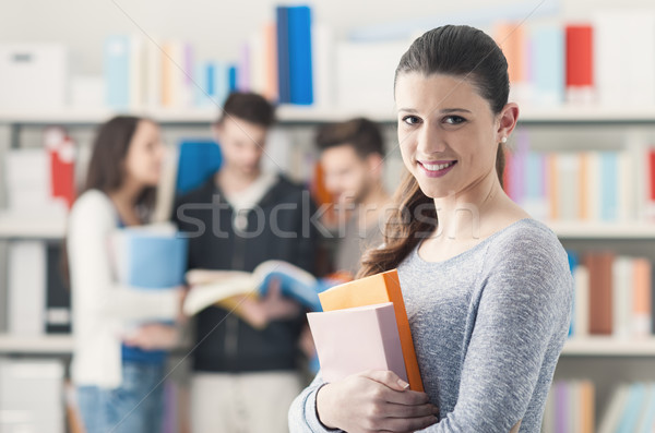Student poseren bibliotheek glimlachend meisje Stockfoto © stokkete