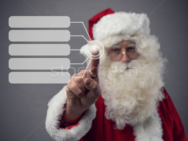 Santa Claus using a touch screen user interface Stock photo © stokkete