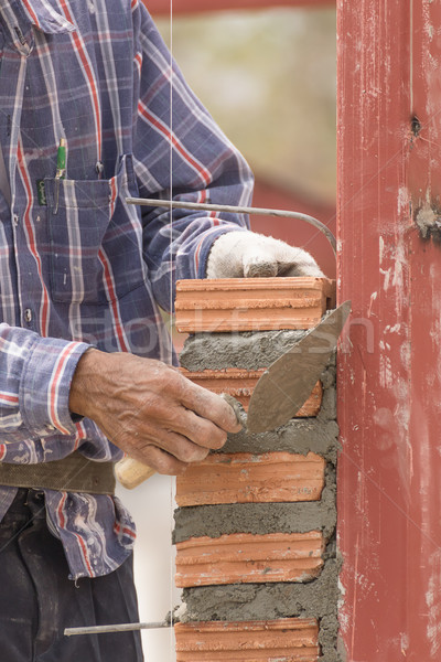 Stock photo: Bricklayer working in construction site of brick wall