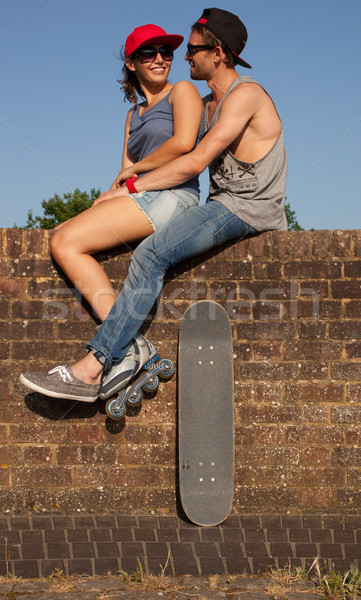 Skateboarder couple séance à l'extérieur femme mur [[stock_photo]] © stryjek