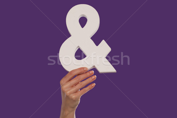 Female hand holding up an ampersand from the bottom Stock photo © stryjek