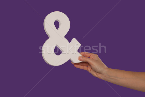 Female hand holding up an ampersand from the right Stock photo © stryjek