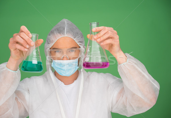 Laboratory technician holding up chemicals Stock photo © stryjek