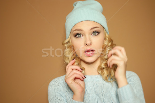 Gorgeous young woman with blond ringlets in a green knitted winter outfit ,over light brown Stock photo © stryjek