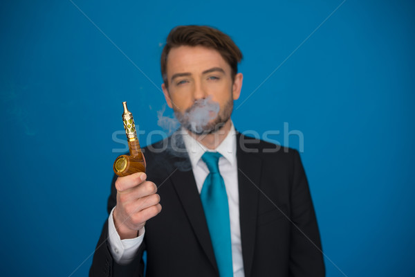 businessman with e-cigarette wearing suit and tie on blue Stock photo © stryjek
