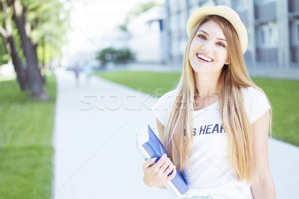 Cheerful Student Girl Holding Books at the Walkway Stock photo © stryjek