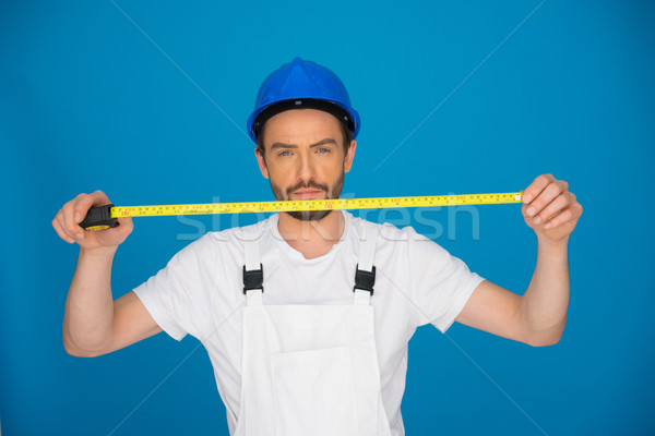 Young builder holding up a measuring tape Stock photo © stryjek