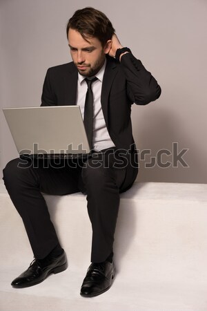 Businessman sitting on a stair working on a laptop Stock photo © stryjek