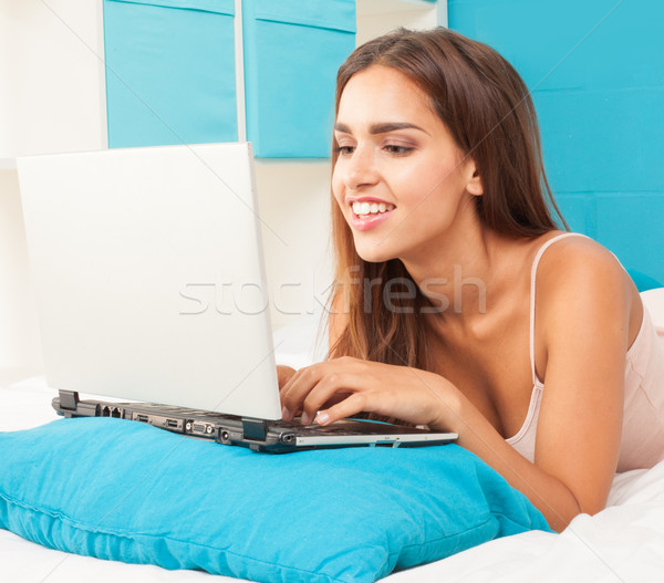 Brunetka kobieta bed pracy laptop uśmiech Zdjęcia stock © stryjek