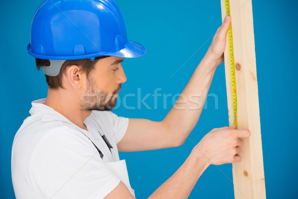 Carpenter or builder measuring a plank of wood Stock photo © stryjek