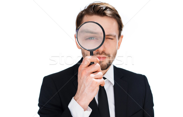 Stock photo: Businessman looking through a magnifying glass
