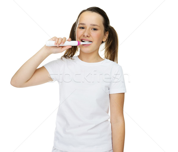 Girl brushing her teeth with an electric brush Stock photo © stryjek