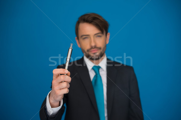 businessman with e-cigarette wearing suit and tie on blue Stock photo © stryjek