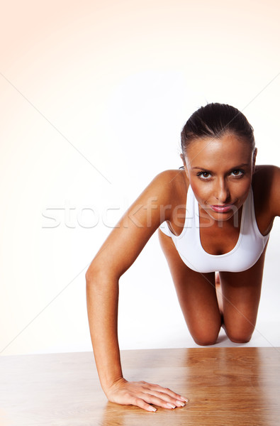 Stock photo: Smiling Young Woman Doing Pushups isolated on white