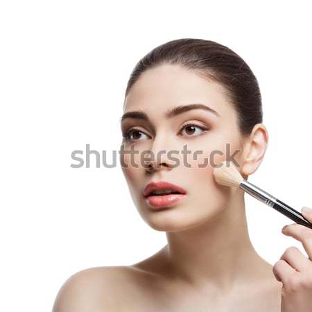 Beautiful girl applying blush with brush Stock photo © svetography