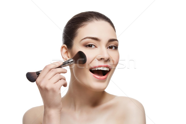 Beautiful happy girl applying blush with brush Stock photo © svetography