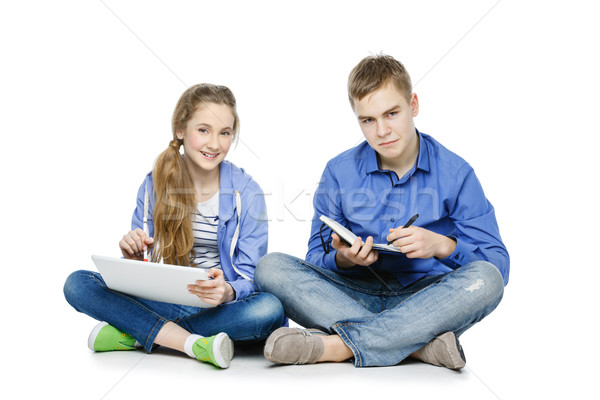 Teen age boy and girl with tablet and notebook Stock photo © svetography