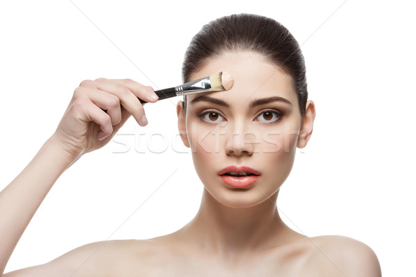 Beautiful girl applying foundation with brush Stock photo © svetography