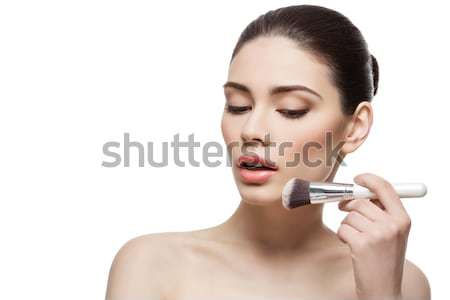 Beautiful girl applying powder with brush Stock photo © svetography